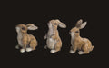 Three rabbit figurines of different sizes on a white background
