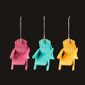 Three colorful Adirondack chair ornaments on a white background